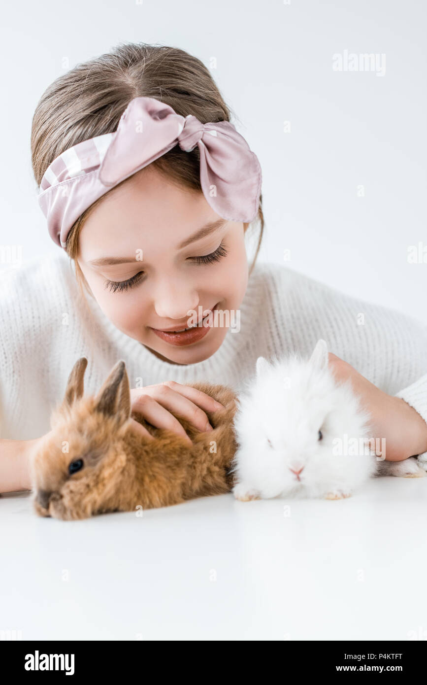 happy child playing with adorable furry rabbits on white Stock Photo