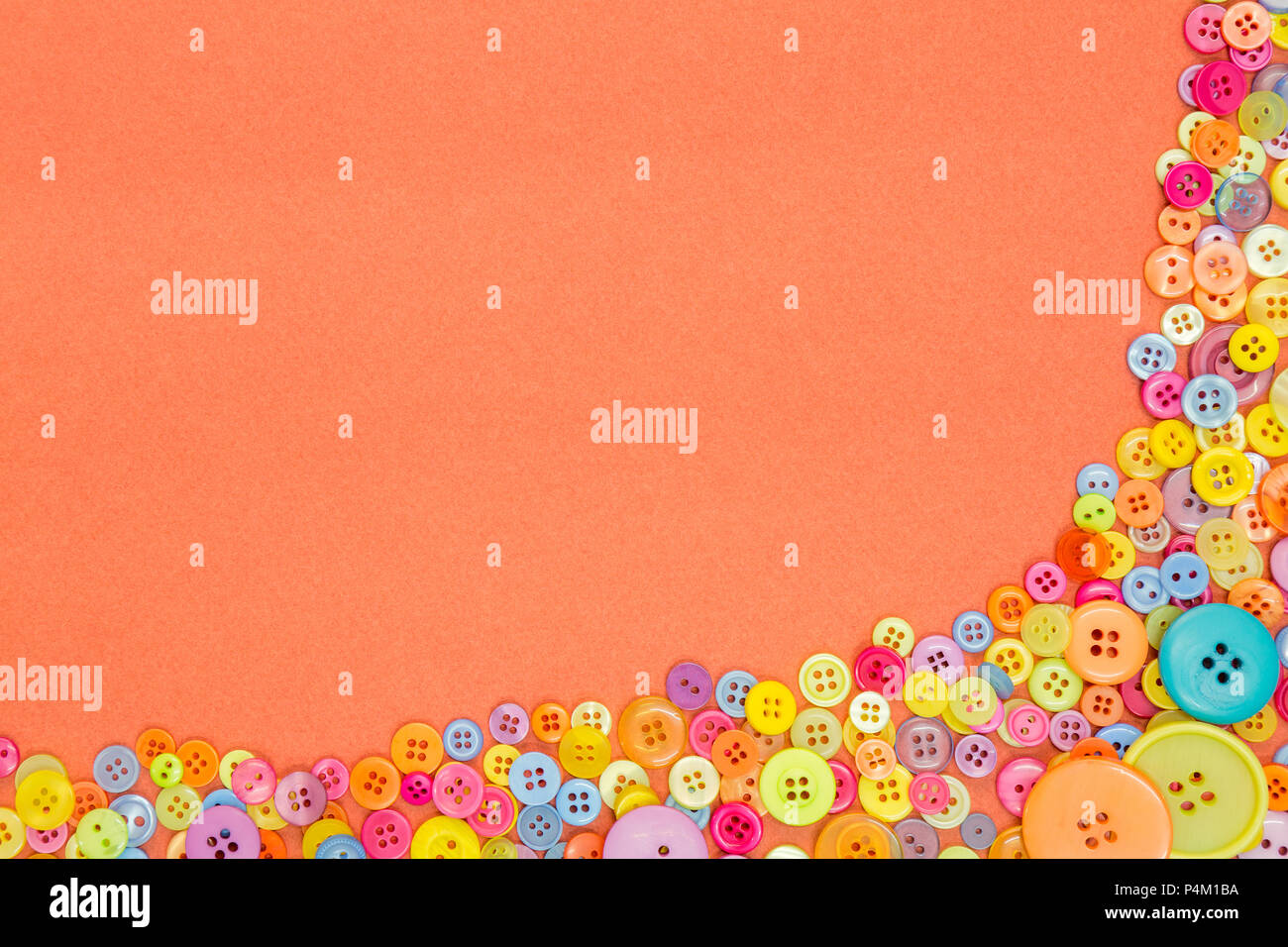 Lots of colourful buttons on an orange textured paper background with blank copy space. Stock Photo