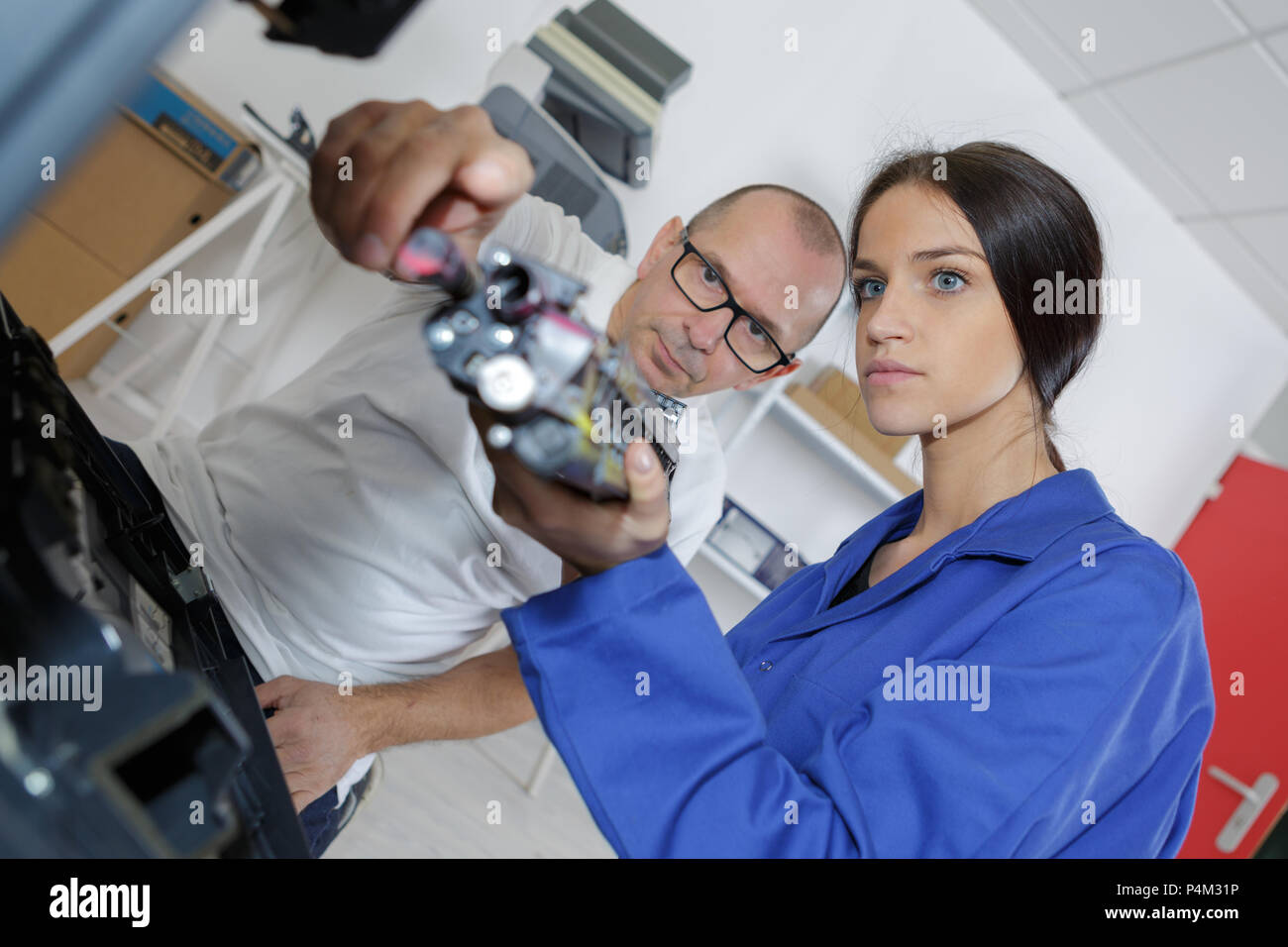 Apprentice holding electrical component Stock Photo Alamy