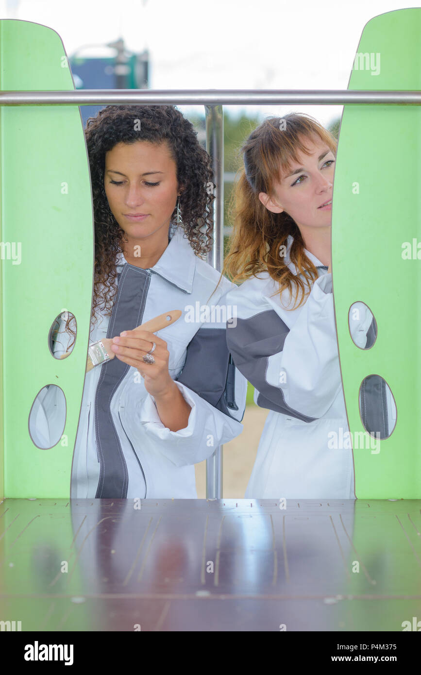 women painting childrens climbing frame Stock Photo Alamy