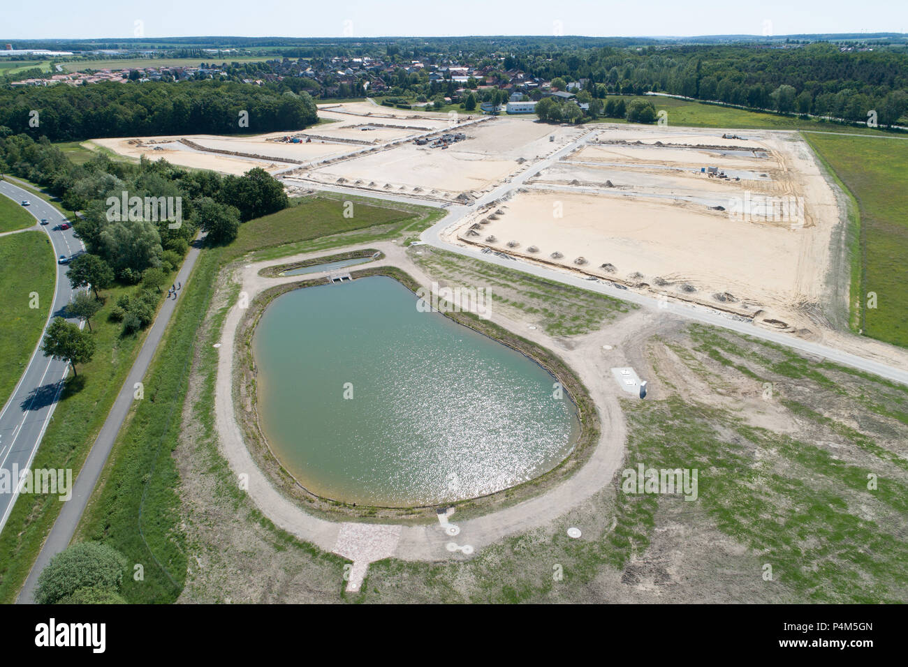 Aerial view from a rainwater basin and a new development area on sandy ground with the planum for new houses, taken at an angle, great height Stock Photo