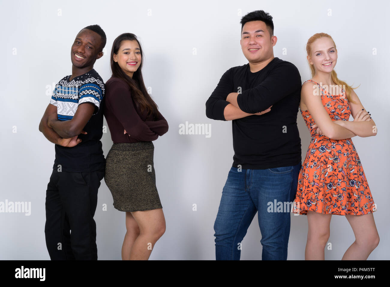 Happy diverse group of multi ethnic friends smiling with arms cr Stock Photo