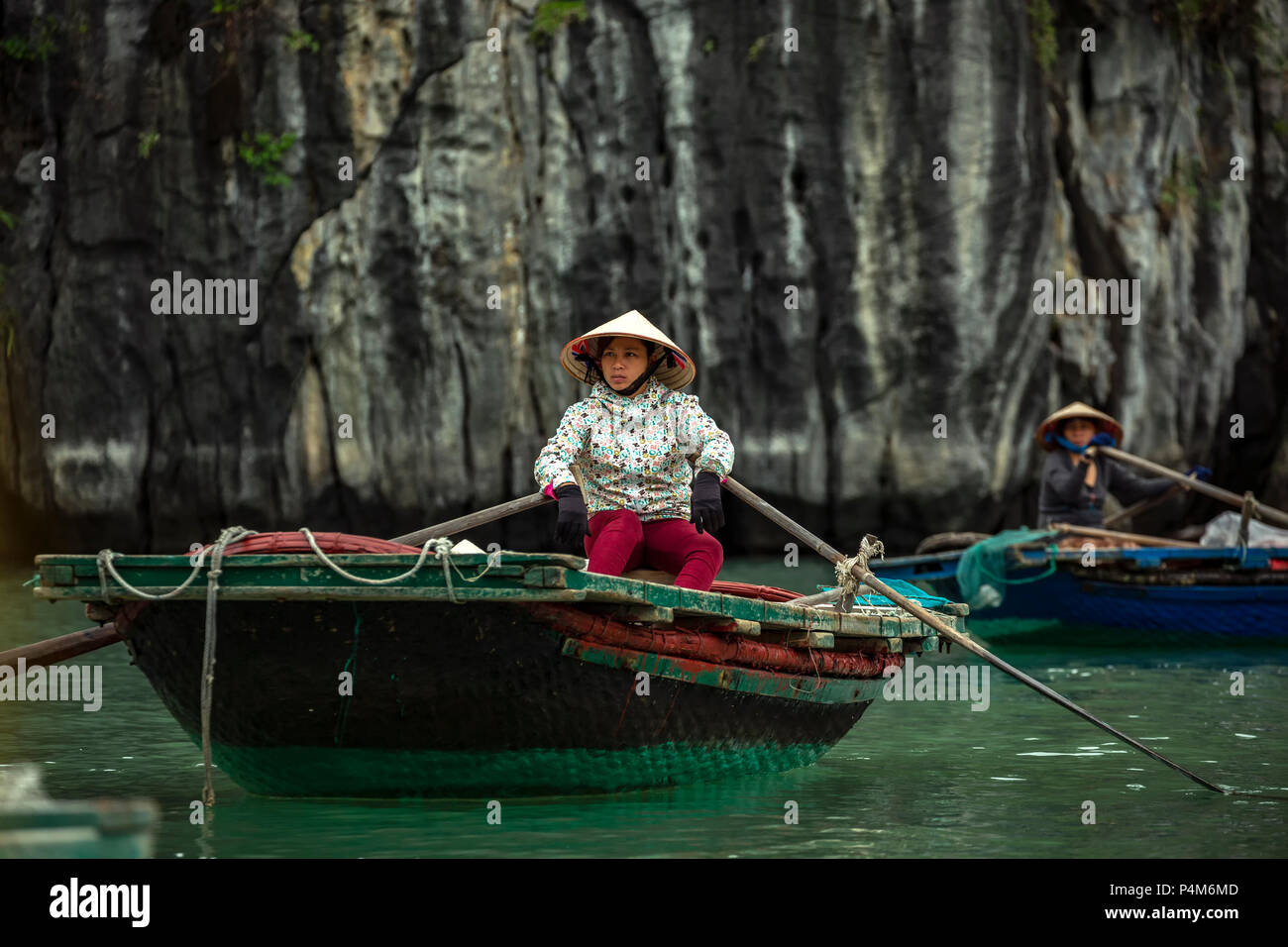 Women rowing wooden rowboats, Vung Vieng fishing village, Ha Long Bay, Bai Tu Long Sector, near Ha Long, Vietnam Stock Photo
