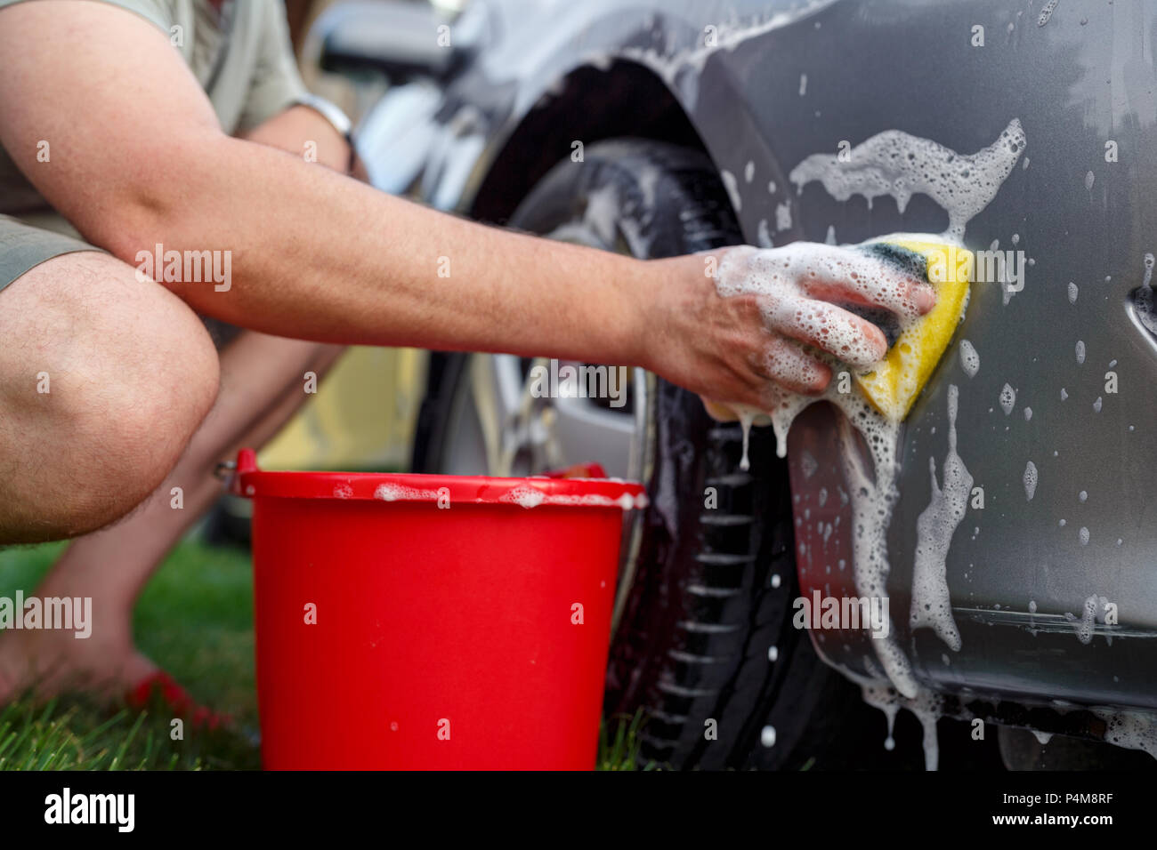 Close up of sponge and bucket -Young man washing his car Stock Photo