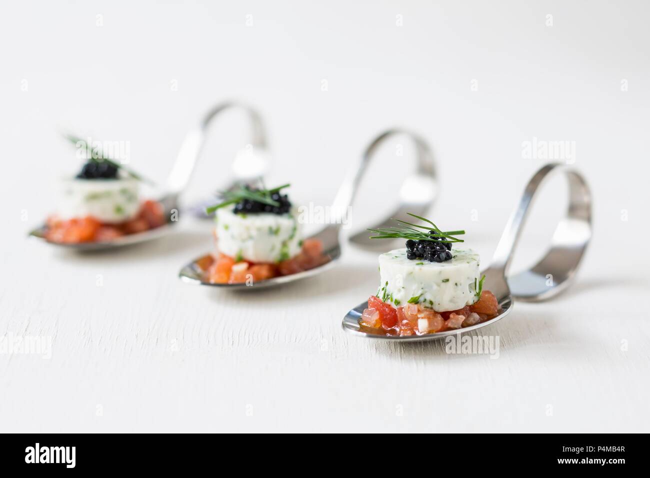 Soya yoghurt terrine on diced tomatoes on canapé spoons Stock Photo