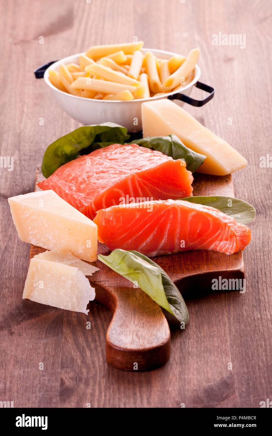 Salmon fillet, spinach leaves, Parmesan and penne pasta Stock Photo