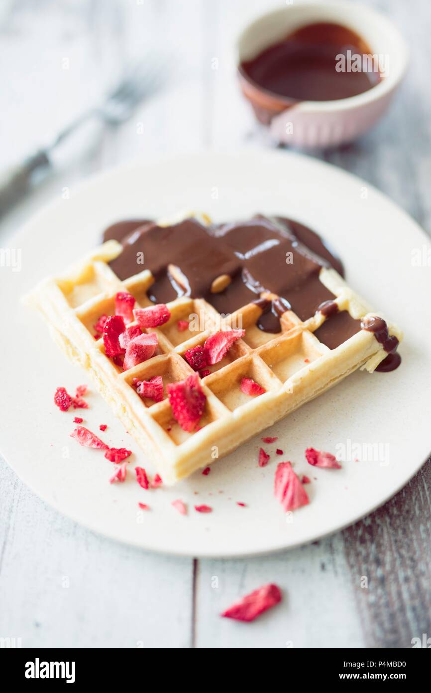 Waffles with dried strawberries and chocolate sauce Stock Photo