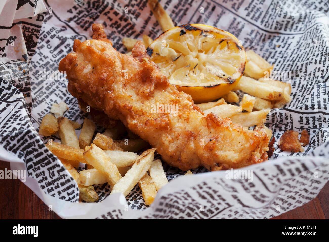 Fish and Chips with Lemon on Newspaper Stock Photo