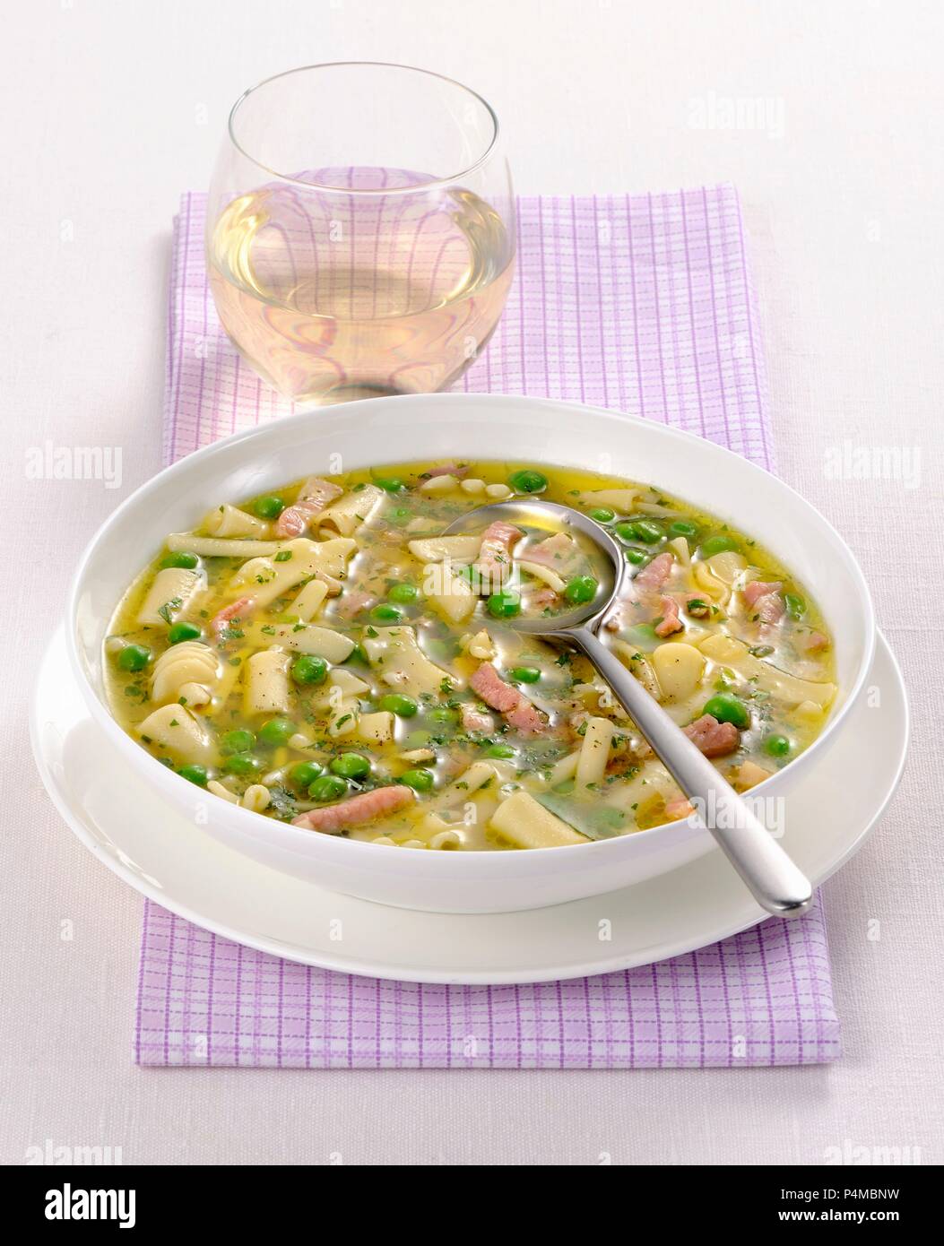 Noodle soup with peas and strips of ham Stock Photo