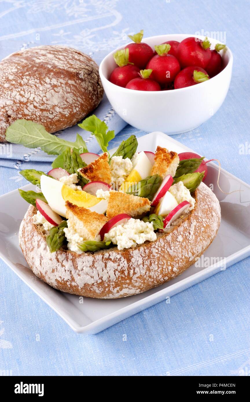 A load of bread filled with goats' cheese, egg, asparagus and radish