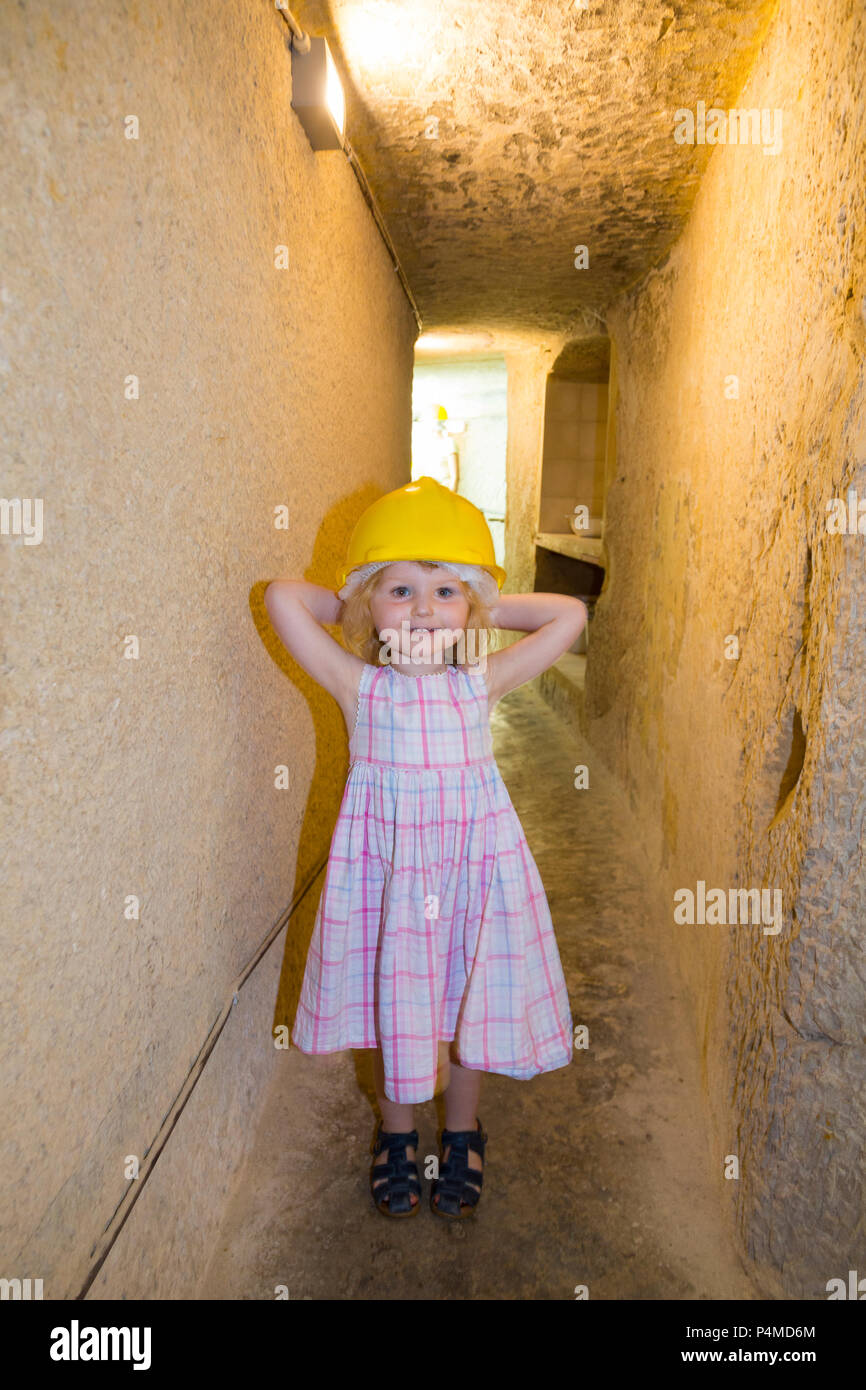 Child / children / kid / kids / family enjoy exploring the air raid shelter tunnel / tunnels inside / underground at the Malta At War Museum, Malta. Stock Photo