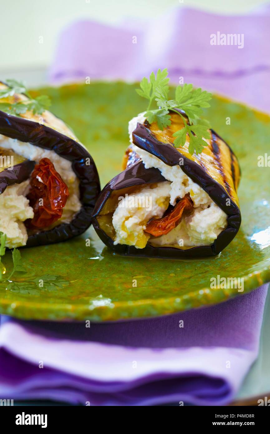 Aubergine rolls with goat's cream cheese, dried tomatoes and olive oil Stock Photo
