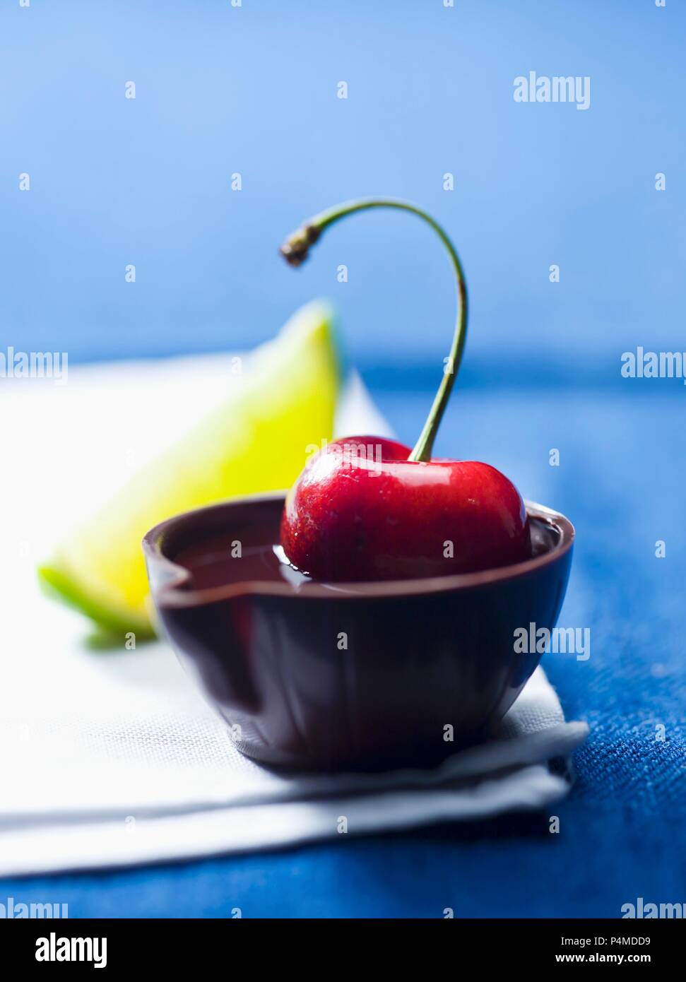 A cherry in alcohol in a tiny bowl made of chocolate Stock Photo Alamy