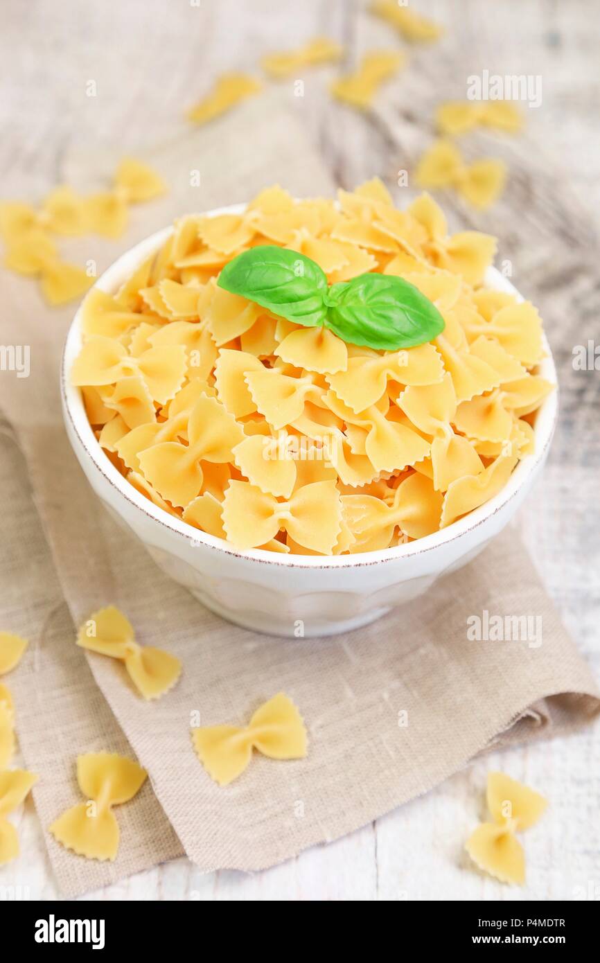 Farfalle pasta in a bowl with fresh basil Stock Photo