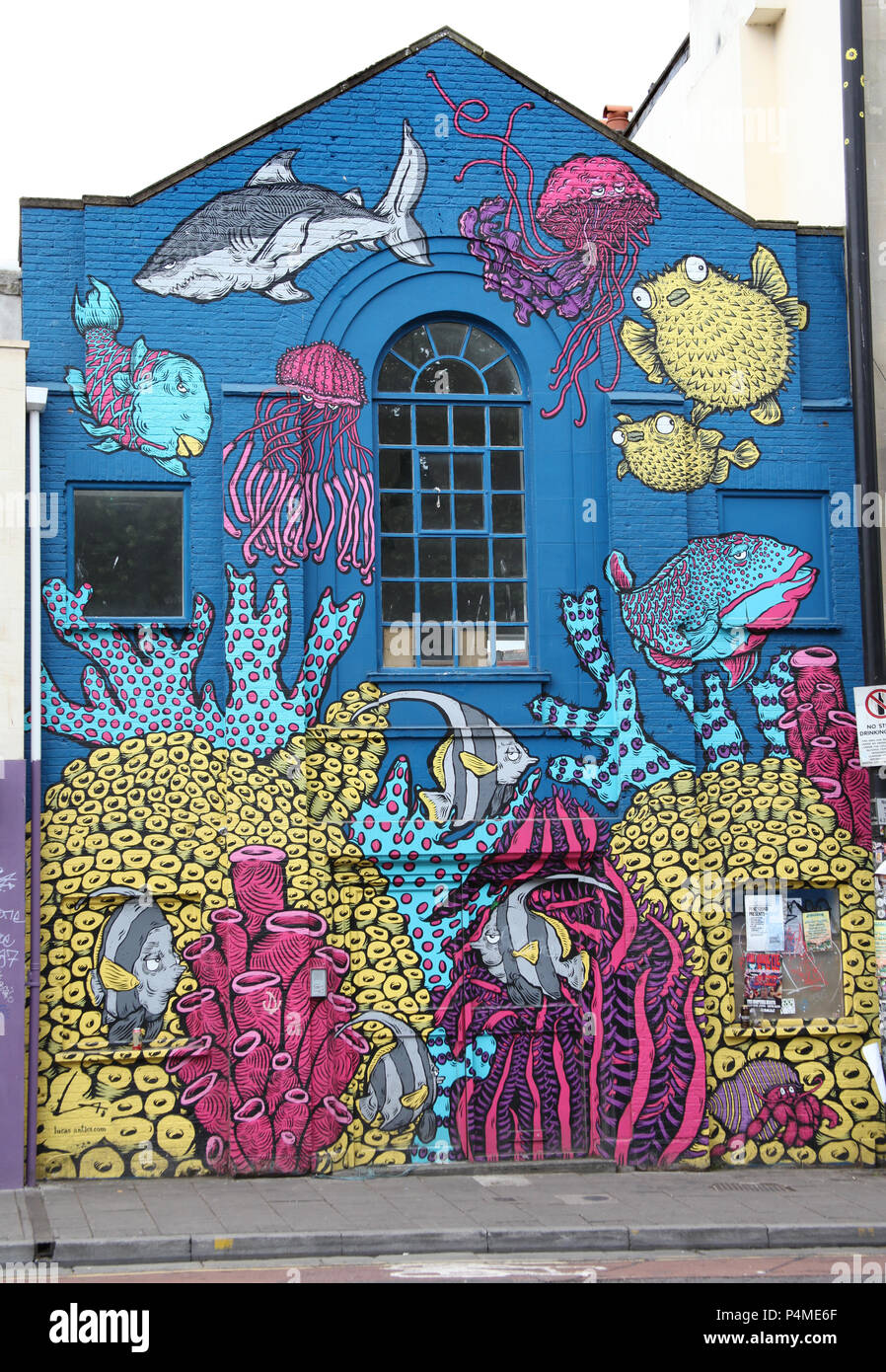 A building in Stokes Croft, Bristol, England painted with fish and an ocean scene. Stock Photo