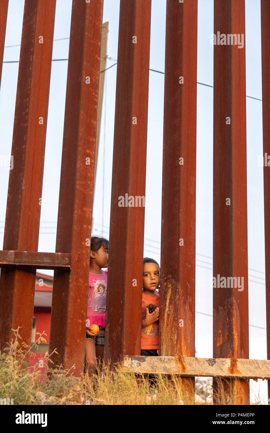 Children play on the Mexican side of the US Mexican border wall, Trump wall, Nogales, USA, Mexico. Stock Photo