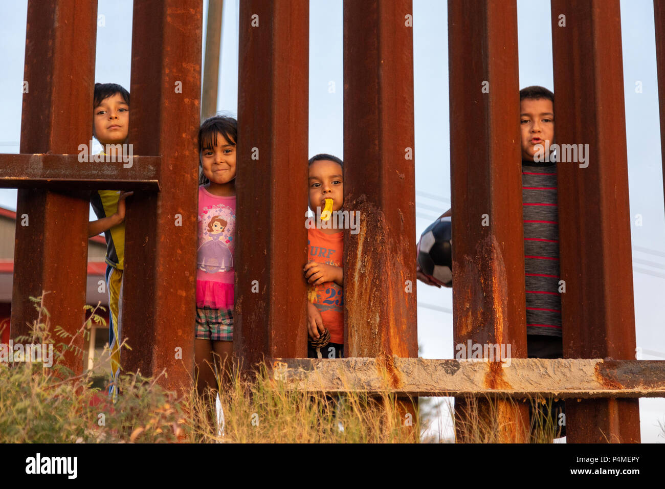 Children play on the Mexican side of the US Mexican border wall, Trump wall, Nogales, USA, Mexico. Stock Photo