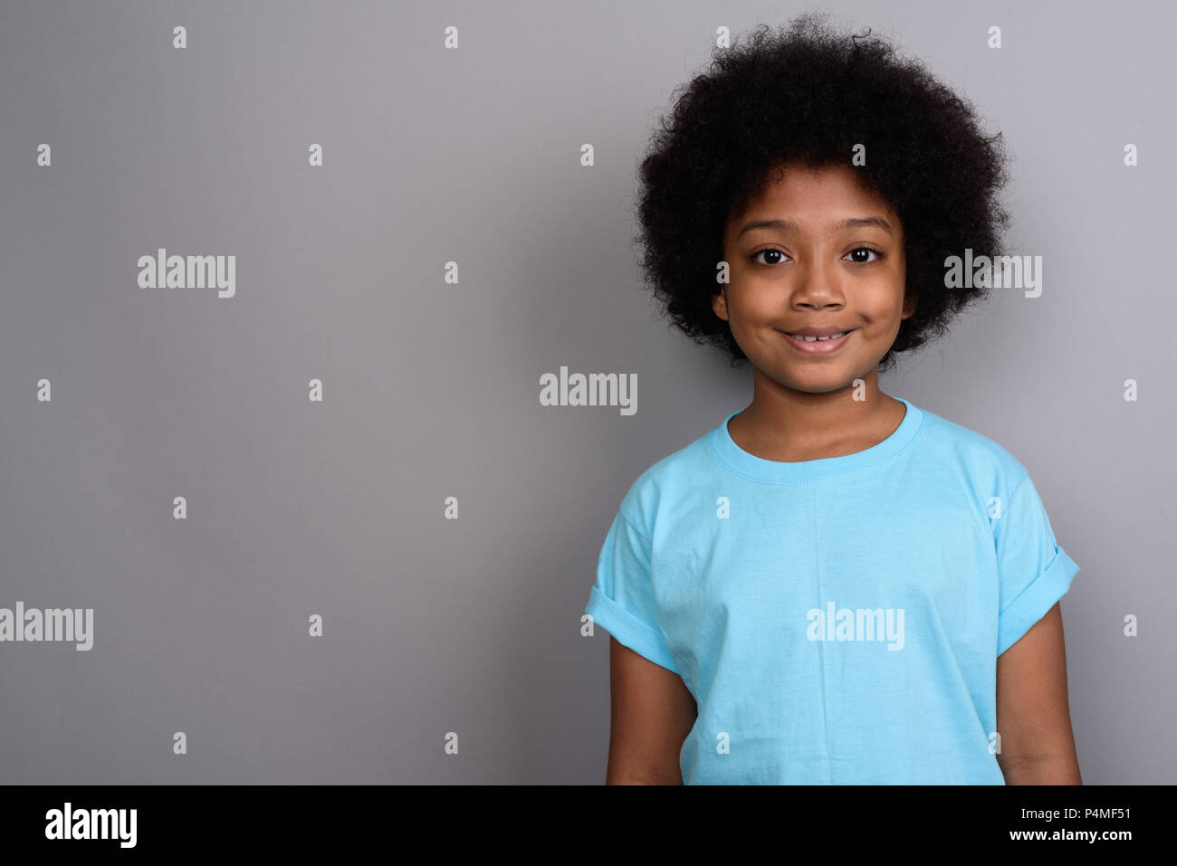 Young cute African girl against gray background Stock Photo