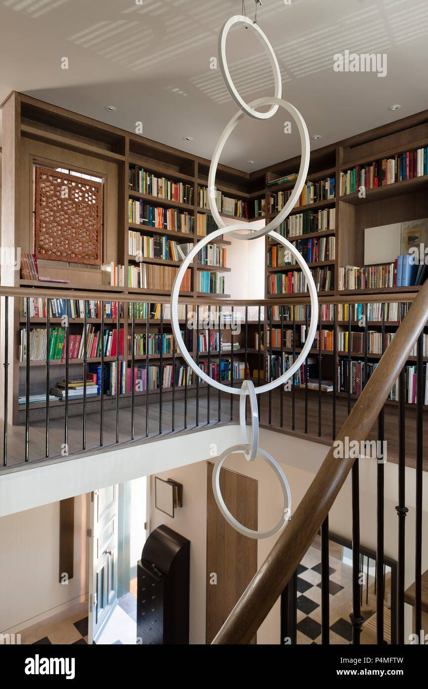 Sculpture hanging by bookcases Stock Photo