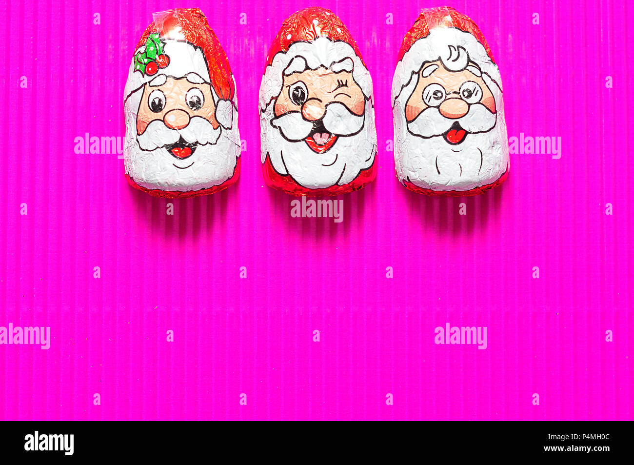 A row of chocolate covered with Santa Clauses face wrappers Stock Photo