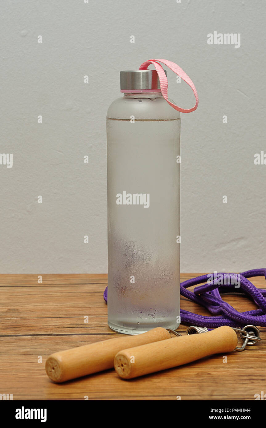 https://c8.alamy.com/comp/P4MHM4/a-glass-bottle-filled-with-ice-cold-water-and-a-jumping-rope-P4MHM4.jpg