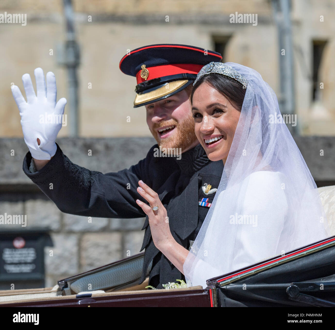 The newly married Duke and Duchess of Sussex depart Windsor Castle in the Ascot Landau carriage during the procession after getting married St George's Chapel, Windsor Castle on May 19, 2018 in Windsor, England.   Prince Henry marries Ms. Meghan Markle in a service at St George's Chapel inside the grounds of Windsor Castle. Stock Photo