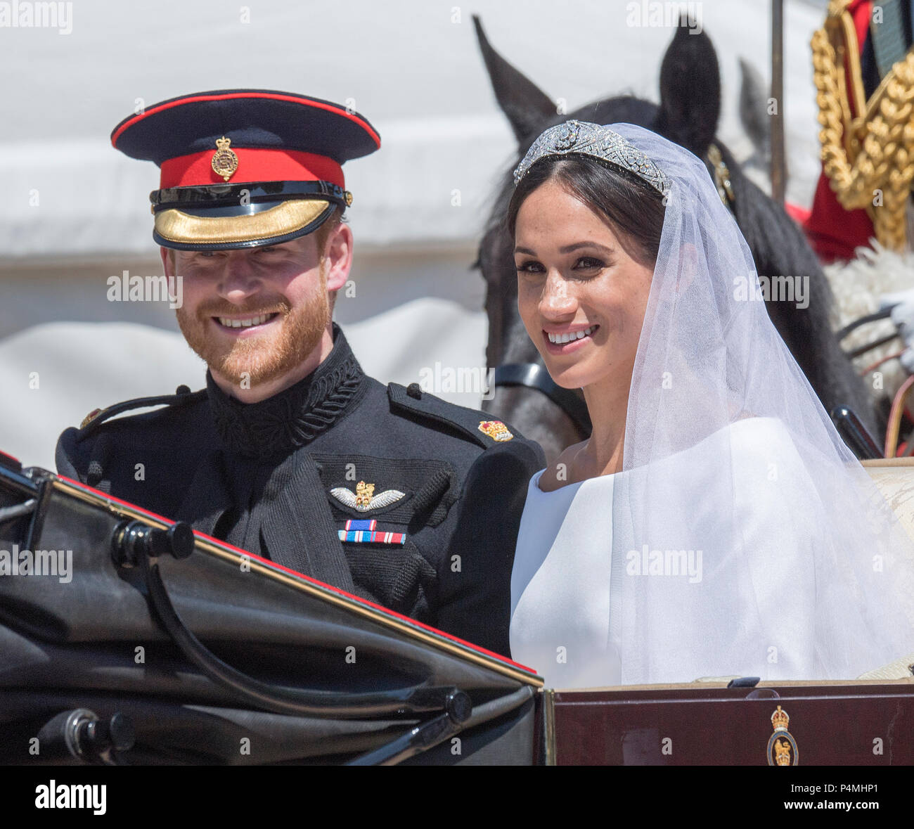 The newly married Duke and Duchess of Sussex depart Windsor Castle in the Ascot Landau carriage during the procession after getting married St George's Chapel, Windsor Castle on May 19, 2018 in Windsor, England.   Prince Henry marries Ms. Meghan Markle in a service at St George's Chapel inside the grounds of Windsor Castle. Stock Photo