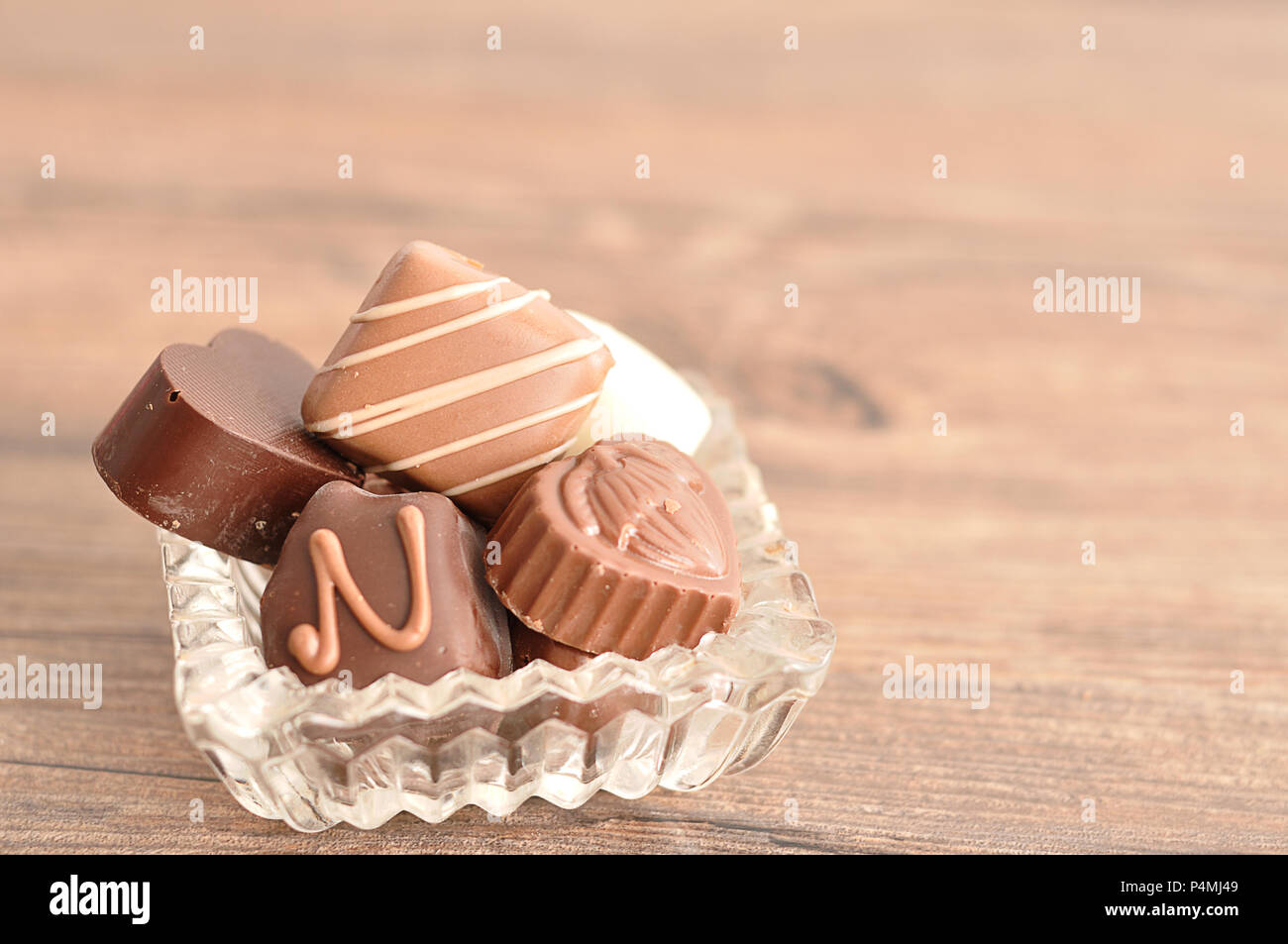 A variety of chocolates displayed in a fancy glass container Stock