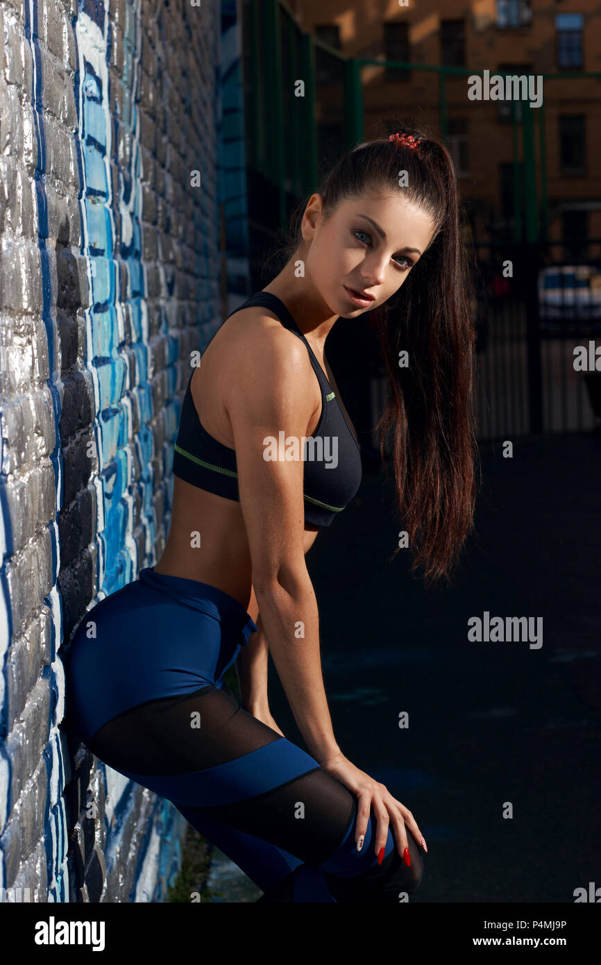 Beautiful fitness woman outdoors. Athletic girl in leggings Stock