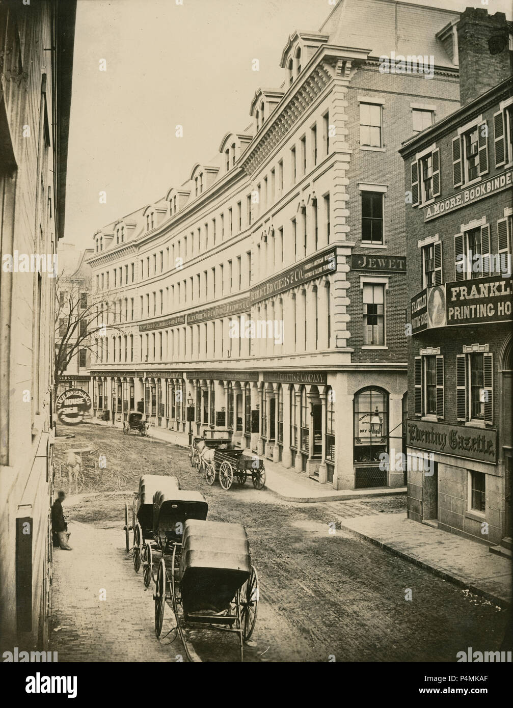 Antique circa 1860 photograph, Franklin Street looking east from Hawley Street, to Arch Street (on right) in Boston, Massachusetts. Old trade signs include Franklin Printing House; Alexander Moore Bookbinder; Burrage Brothers & Co.; Jewett Tebbetts & Co.; Allen Whiting & Co.; Dodge Baldwin & Co.; Austin Sumner & Co.; Denny Rice & Co. American Goods & Wool; B.C. Howard & Co.; Woodman Horswell & Co.; Wilkinson Stetson & Co.; J.W.H. Rogers & Co. House and Sign Painting. Most of the area was destroyed in the Great Boston fire of 1872. SOURCE: LATER GENERATION HIGH QUALITY PHOTOGRAPH Stock Photo