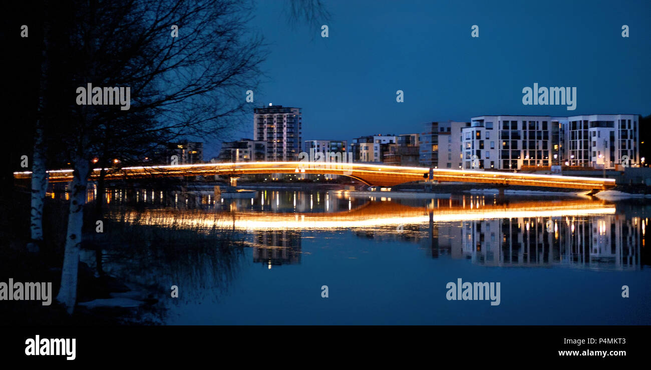 Night scene with blue sky, buildings and bridge with mirror effect  in Joensuu in Finland. Stock Photo