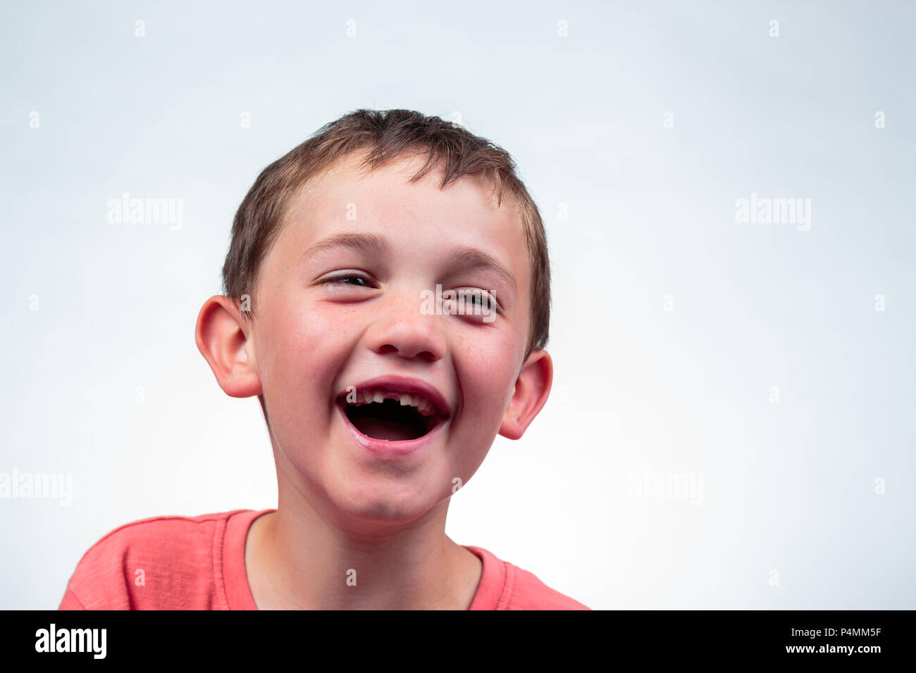 Close up portrait of a caucasian 8 year old boy laughing with open ...