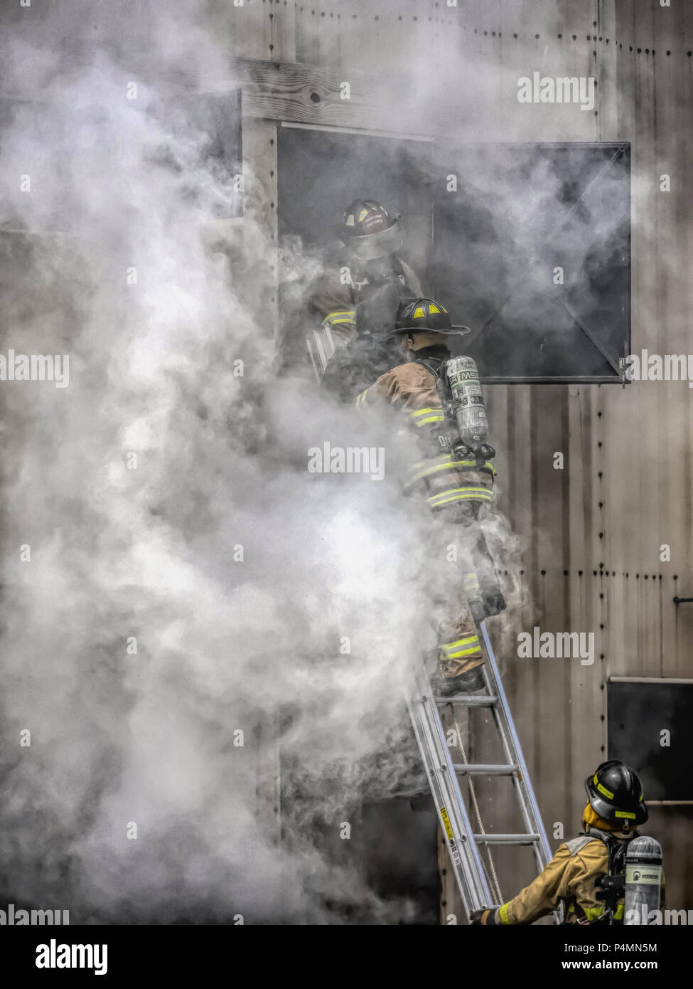Firefighters coming down a ladder at a rescue training facility. Stock Photo