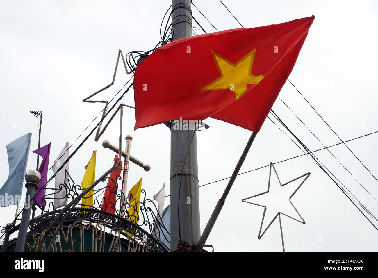 Vietnam Red Country flag, Star of Bethlehem and cross in front of the entrance to the church of Phu Ly (Ha Nam province), Hanoi, Vietnam Stock Photo