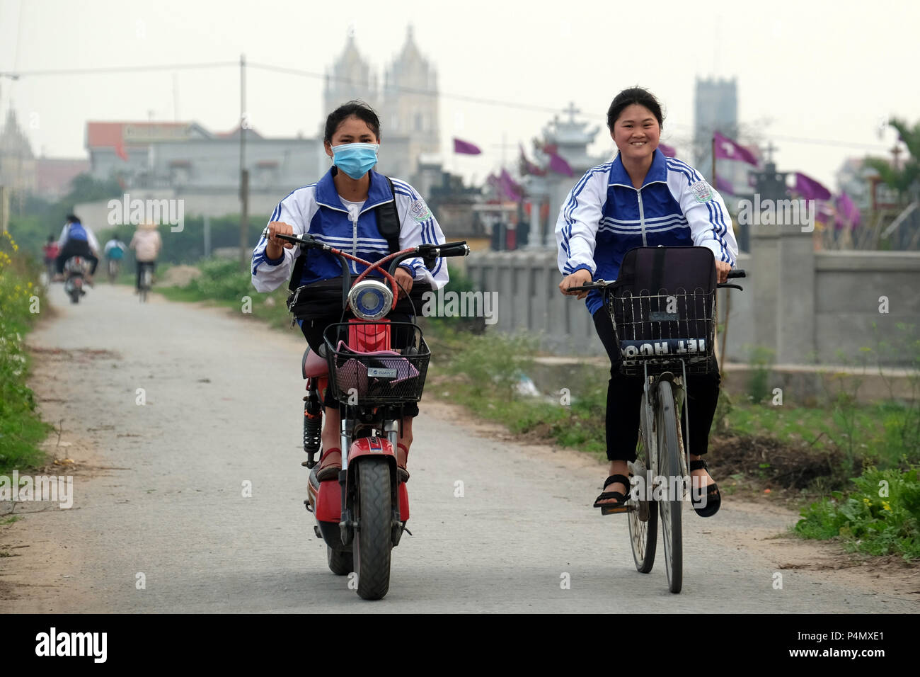 Women on bicycle and electro bike in Nam Dinh province, Vietnam - Frauen auf Fahrrad und E-bike in der Nam Dinh-Provinz, Vietnam Stock Photo