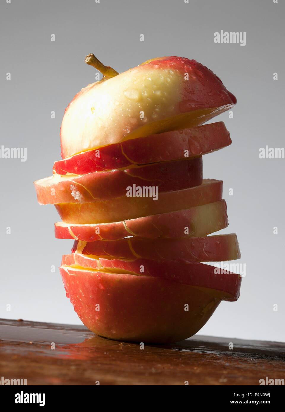 An apple cut into slices, with water drops Stock Photo Alamy
