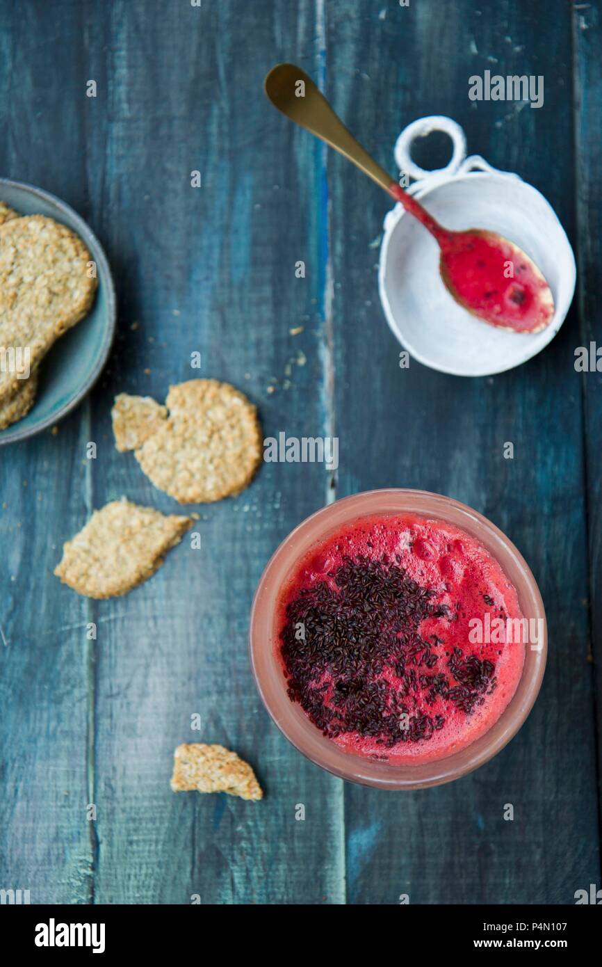 A beetroot smoothie with carrots, pineapple and chia seeds, with oat biscuits Stock Photo