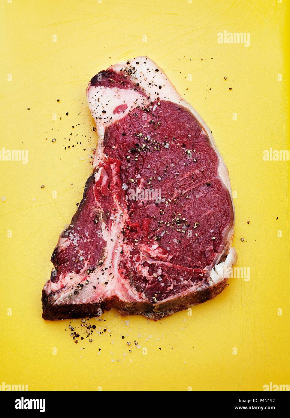 A raw Tbone steak seasoned with salt and pepper Stock Photo Alamy