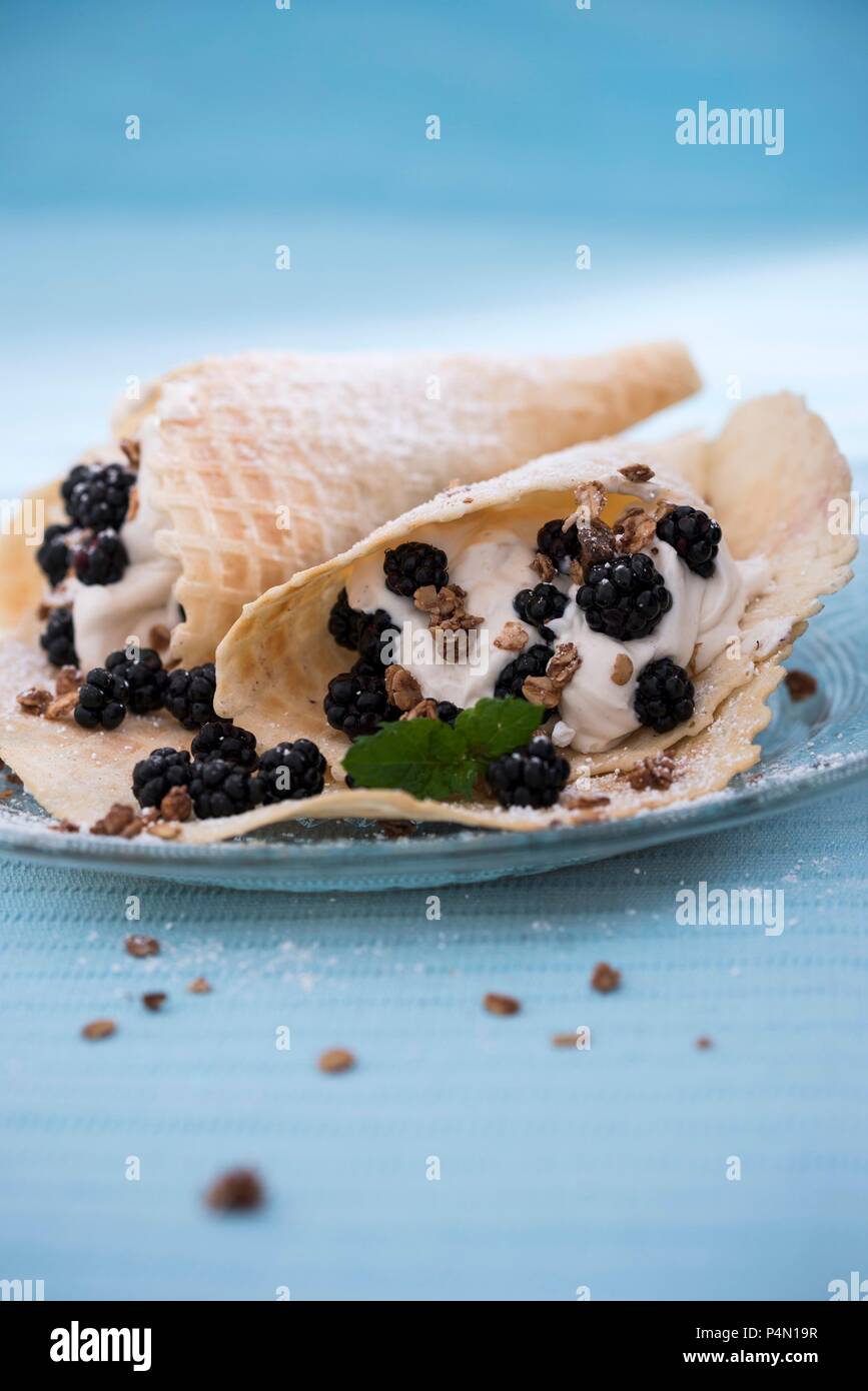 Waffles with vegan vanilla cream, blackberries and crunchy muesli Stock Photo