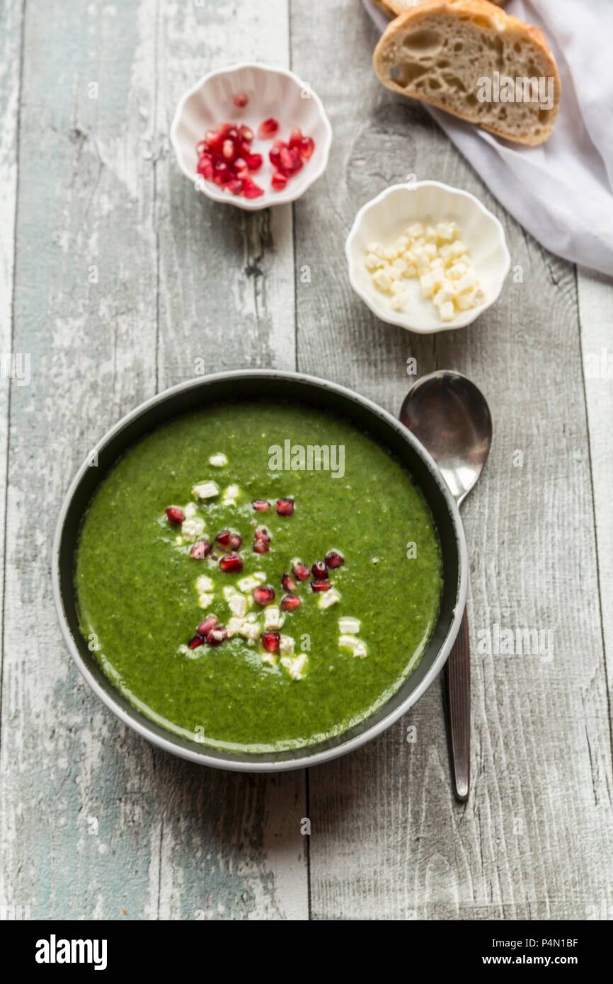 Green cabbage soup with pomegranate seeds and feta cubes Stock Photo