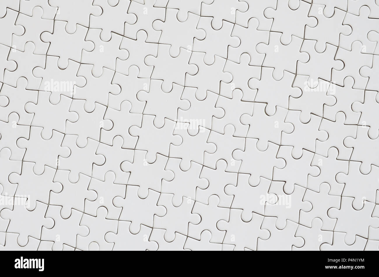 Close up texture of a white jigsaw puzzle in assembled condition. Top