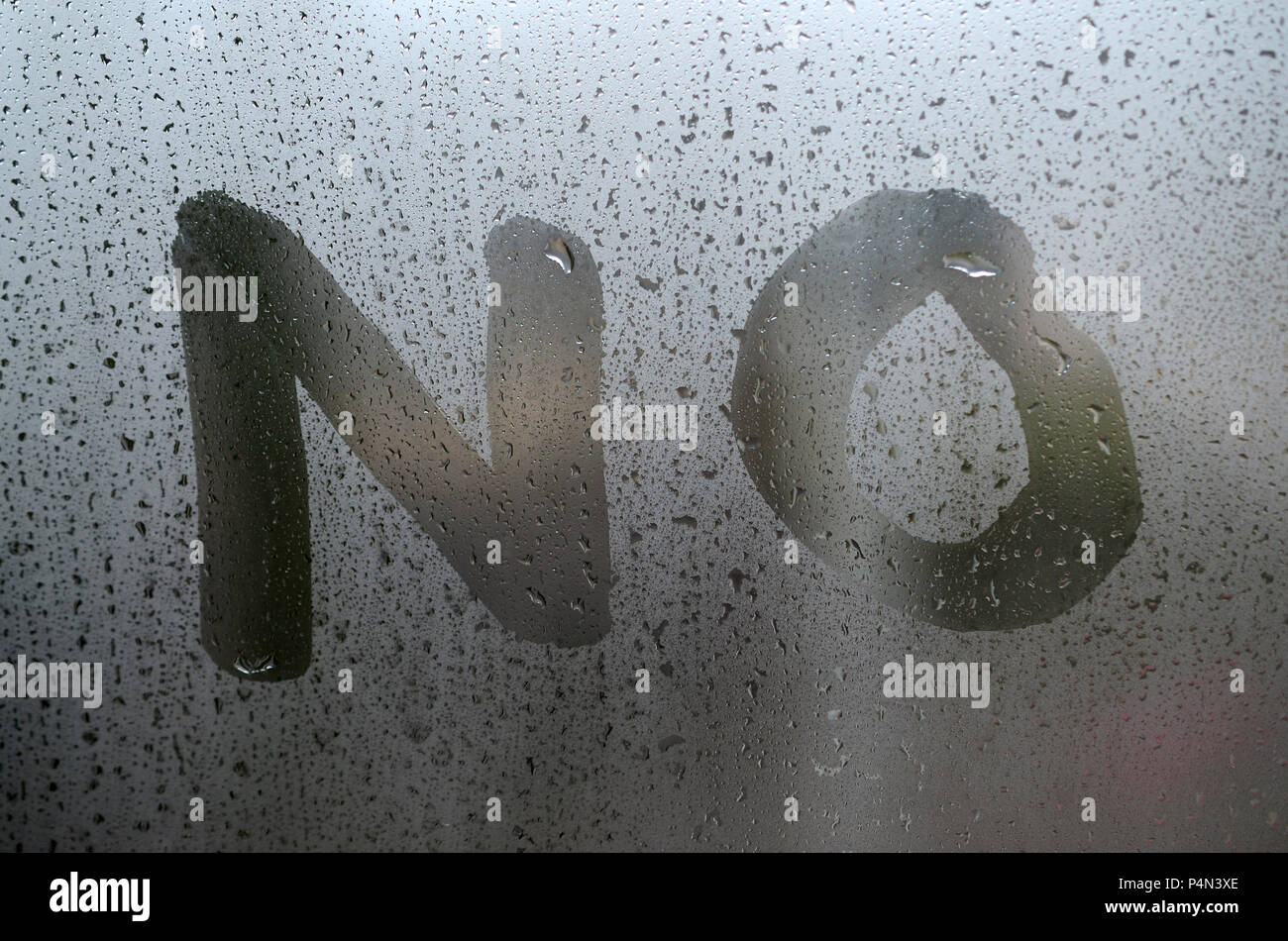 The English word No is written with a finger on the surface of the misted glass . Stock Photo