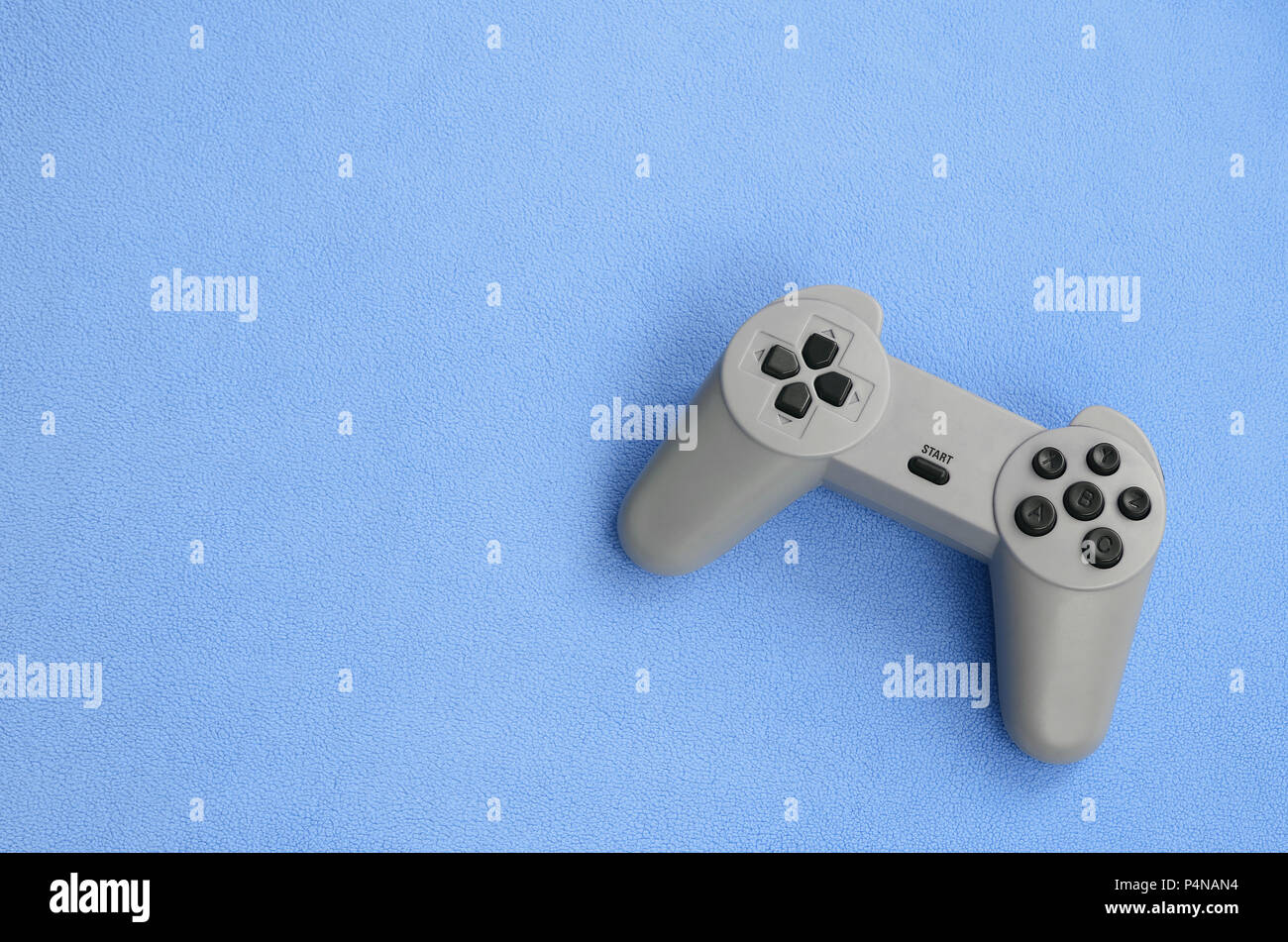 Playing games concept. Single pad joystick lies on the blanket of furry  blue fleece fabric. Controller for video games on a background texture of  ligh Stock Photo - Alamy