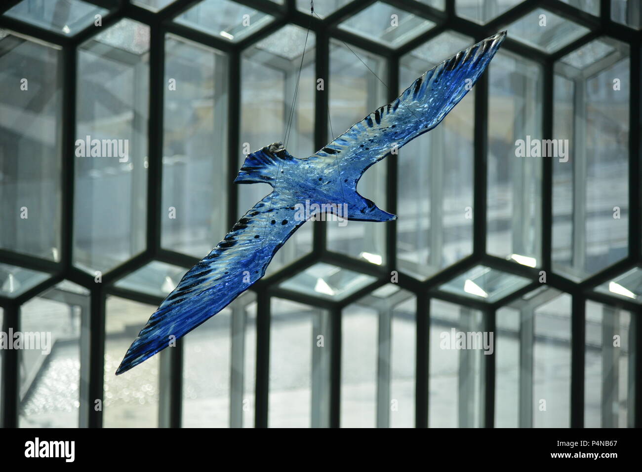 Blue glass bird flying through the interior of the famous Harpa concert hall in Reykjavik, Iceland Stock Photo