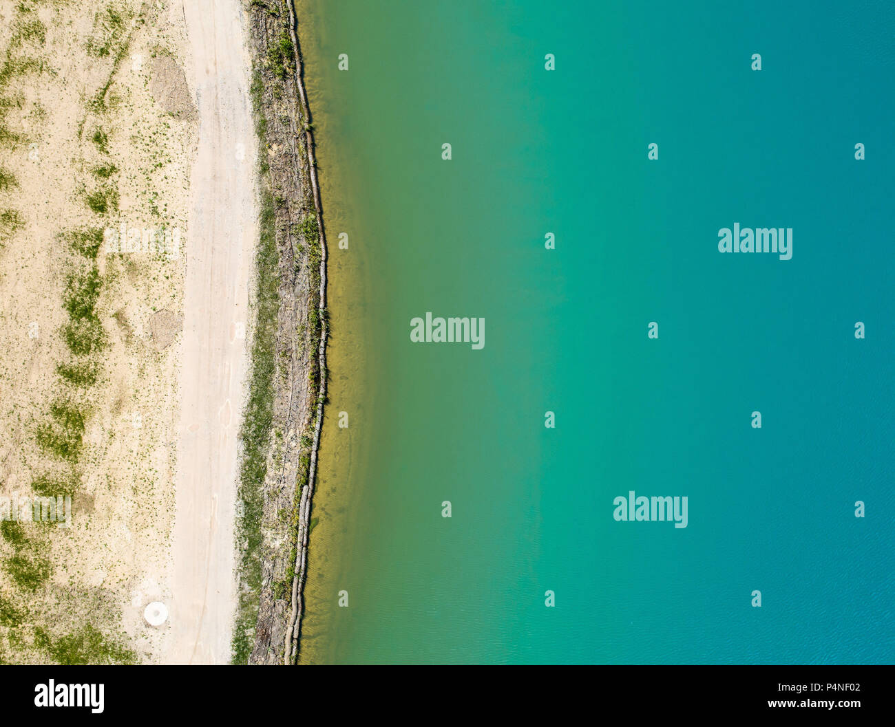 Detailed view of the edge of a rainwater retention basin with turquoise coloured water, abstract effect through vertical angle of view, Germany Stock Photo