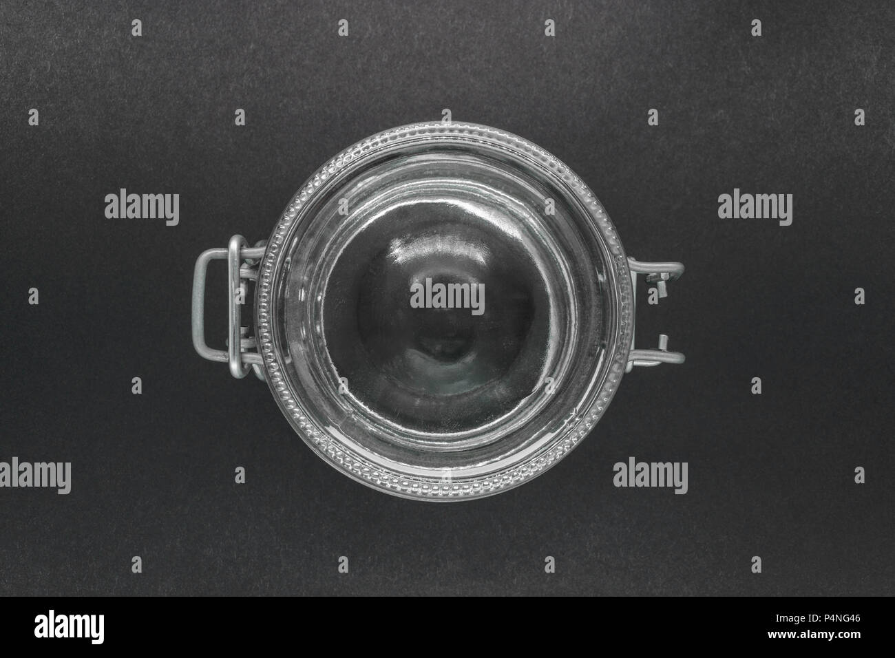 View from top of closed glass jar with metal holder on black background surface Stock Photo