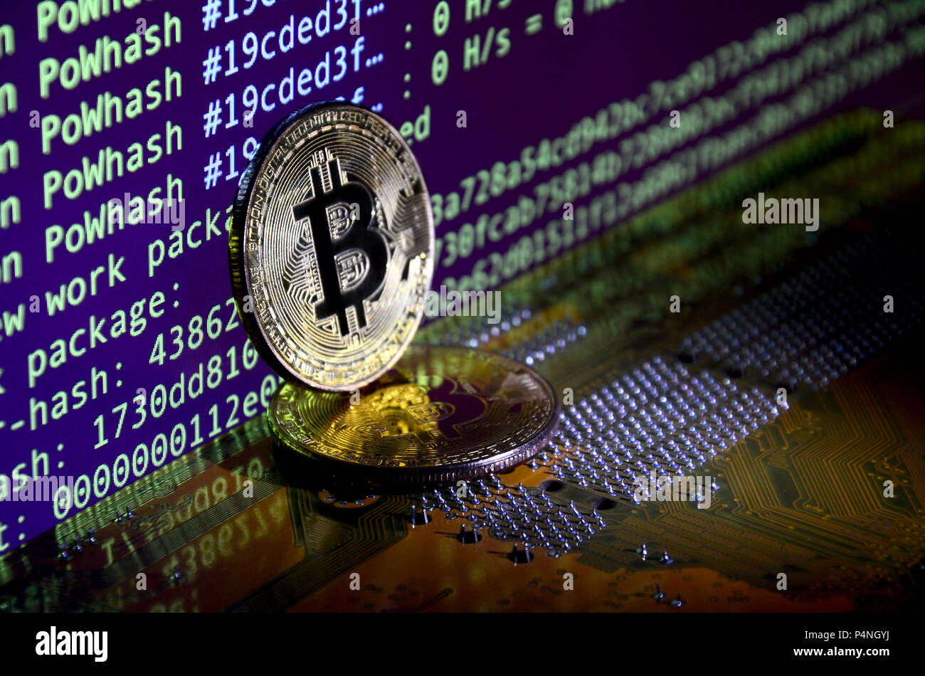 Two bitcoins lies on a videocard surface with background of screen ...