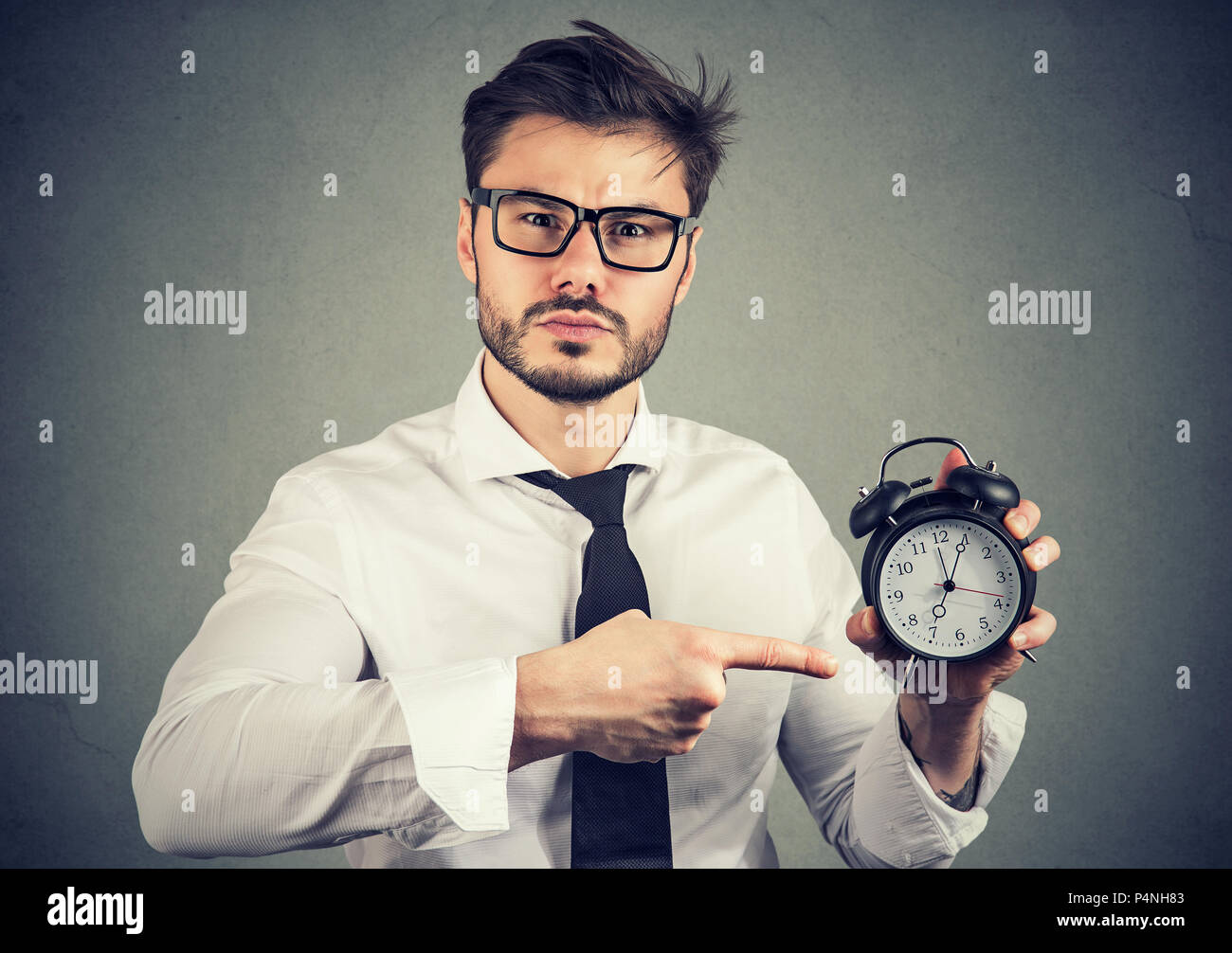 Adult formal man in glasses looking seriously at camera and pointing at ...