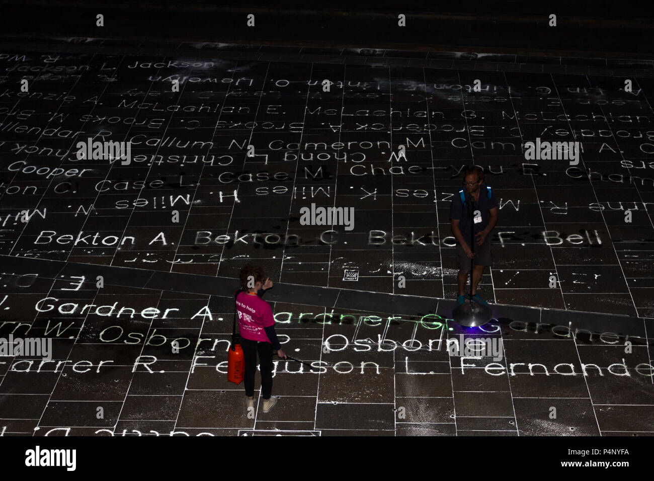 London, UK. 22nd June 2018. Temporary Art Installation commemorating 492 people who arrived at Tilbury Dock on the ship Empire Windrush in 1948. Art work by Roy Williams and Gijs Van Bon. Part of Greenwich + Docklands International Festival GDIF. Names of all 492 individuals are transcribed in photoluminescent powder onto the pavement in Cutty Sark Gardens to pay tribute them. Credit: Ann O’Toole/Alamy Live News Stock Photo