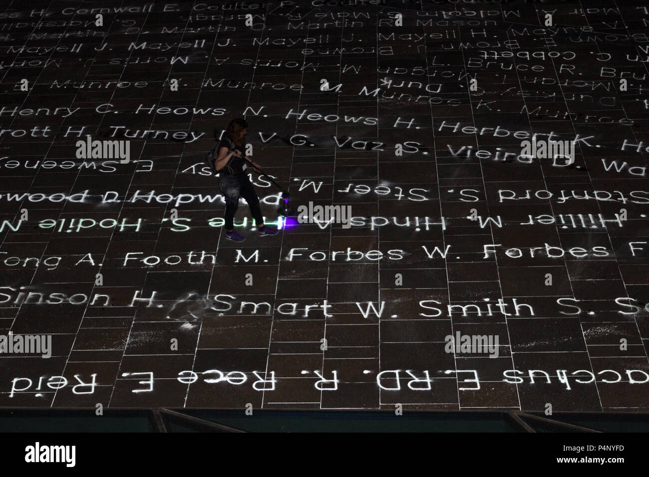 London, UK. 22nd June 2018. Temporary Art Installation commemorating 492 people who arrived at Tilbury Dock on the ship Empire Windrush in 1948. Art work by Roy Williams and Gijs Van Bon. Part of Greenwich + Docklands International Festival GDIF. Names of all 492 individuals are transcribed in photoluminescent powder onto the pavement in Cutty Sark Gardens to pay tribute them. Credit: Ann O’Toole/Alamy Live News Stock Photo